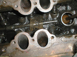 Rear of flathead V8 engine with intake manifold return. The push rod for the fuel pump is on the right.
