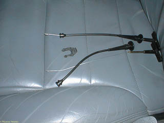 From top to bottom, the new parking brake release cable, the retaining clip, and the broken parking brake release cable