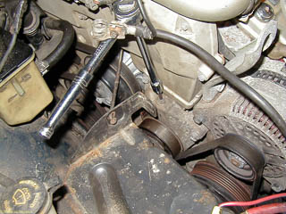 Use a socket wrench extension with a 5mm hex drive to loosen belt tension.
