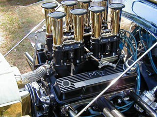Chevy big block engine with four Weber carburetors and polished velocity stack air horns